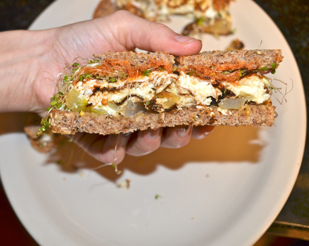 Egg whites with onion, cholula, and zesty sprouts on sesame ezekiel bread